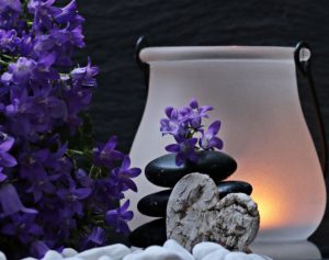 Photo of flowers, and a candle in a jar