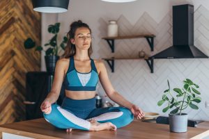 Woman meditating on top of her desk