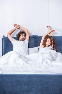 Couple stretch in bed