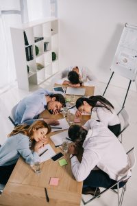 Workers sleeping around a common desk