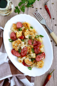 Warm salad of cauliflower, grilled sausages, green onions. 